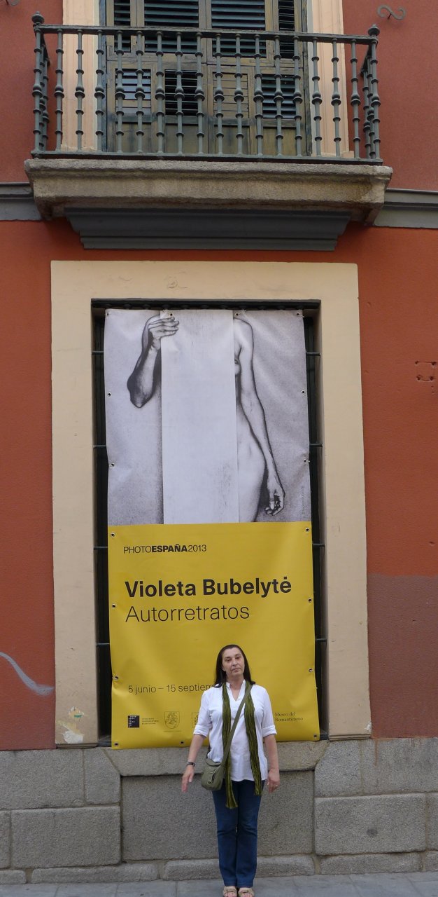 Parodos „Autoportretai“ autorė Violeta Bubelytė prie parodos plakato.